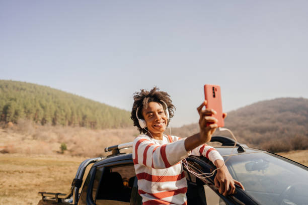 istock Young woman having a video call while on a road trip 1324377870