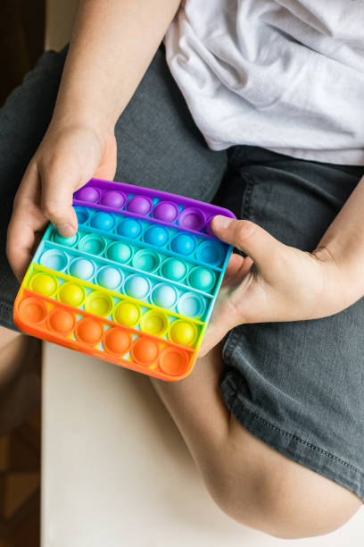 istock Pop it. The boy plays a trendy children's toy. 1324378261