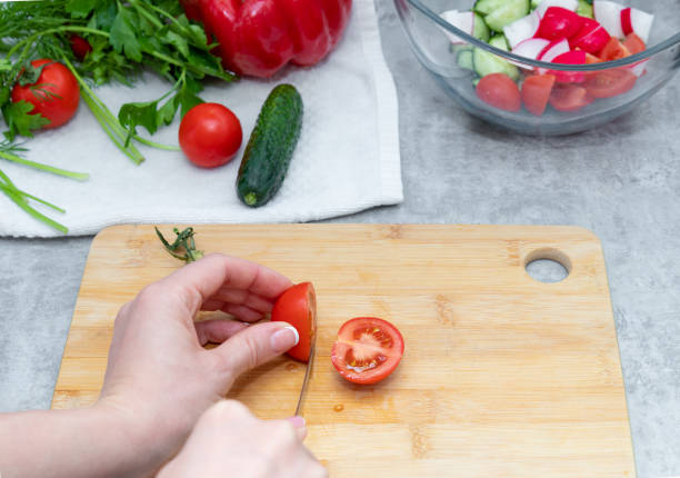 istock Cutting of tomatoes at home kitchen. 1324380323