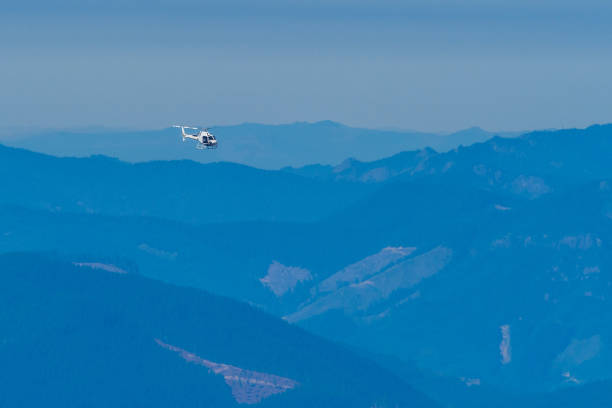 istock Helicopter flying above mountains 1324380606