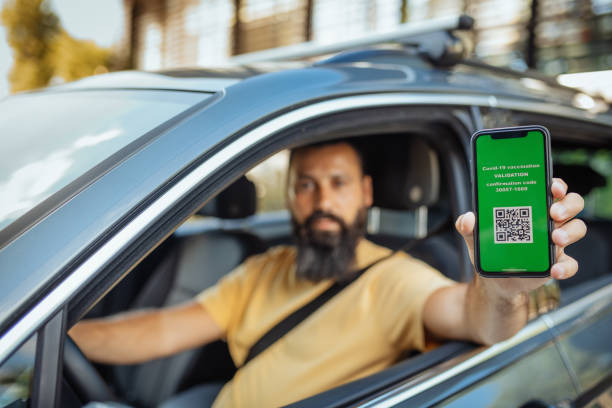 istock Mature man showing immunisation certificate while driving car 1324380681