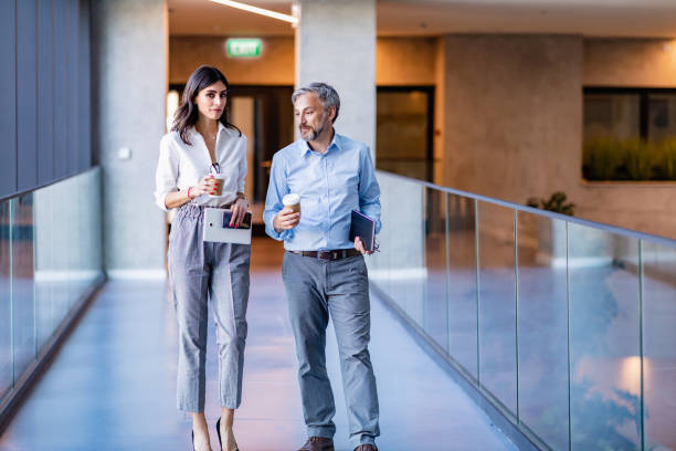 istock Confident business partners walking down in office building and talking 1324384397