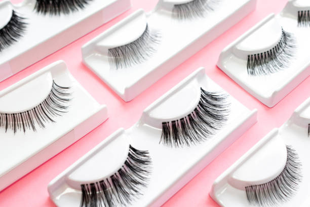 istock Different fake eyelashes on a trendy pastel pink background. Beauty pop art pattern. Makeup accessories. Cosmetics products for women. Bright colorful backdrop. Close up. Flat lay. Top view 1324385355