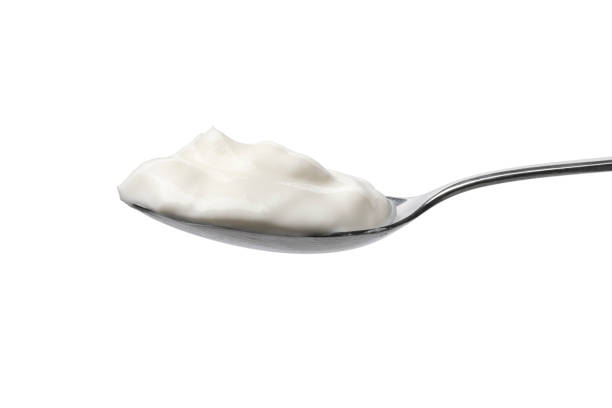 istock Metal spoon with Greek yoghurt on white background 1324386353