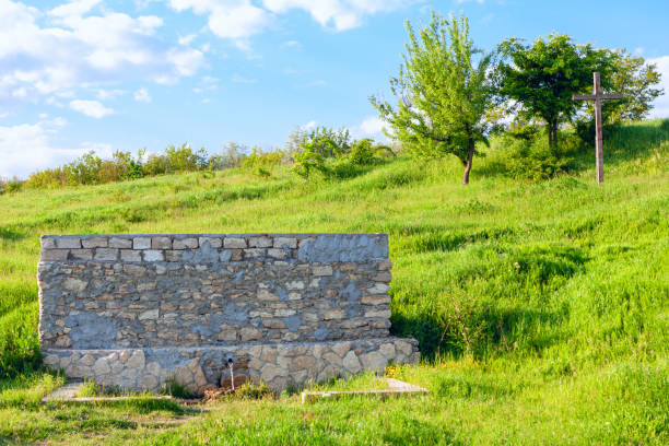 Fresh mineral water from a natural water source . Source of groundwater . Cross on the hill near water spring
