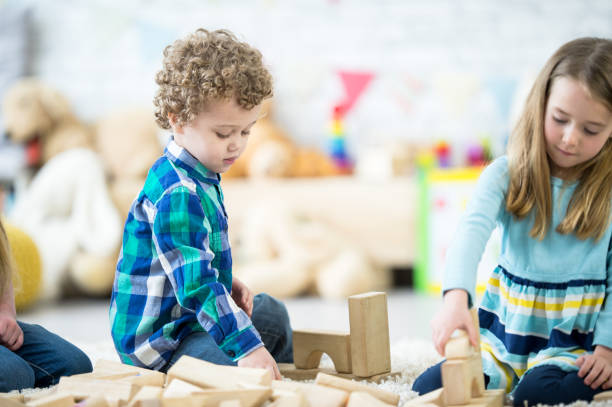 istock Preschool kids playing with wooden blocks 1324388902