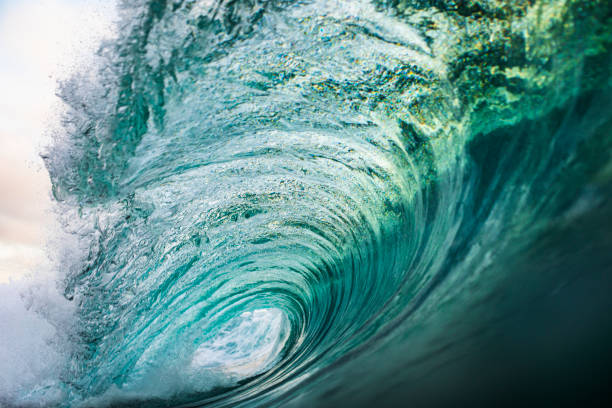 istock Bright Blue Wave powerfully breaking in morning light 1324402859