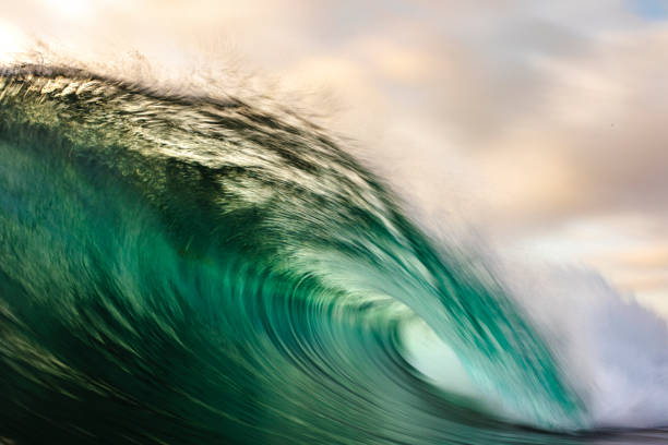 движение пятно глубокой зеленой океанской волны, разбиваемой в золотом свете - metal verdigris textured effect textured стоковые фото и изображения