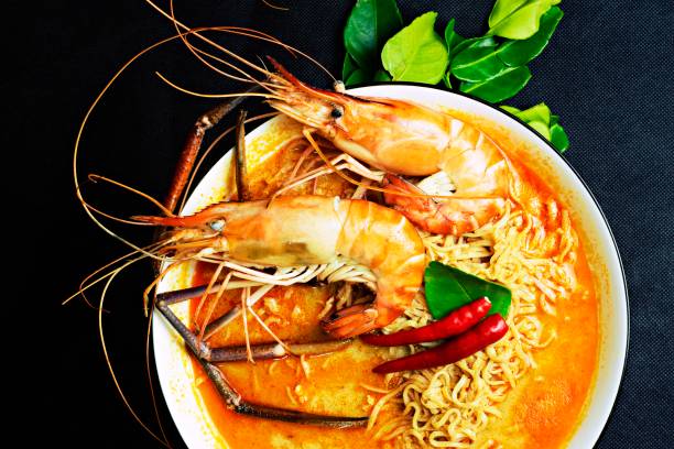 istock Cooked shrimps in spicy noodle bowl - black background. 1324403437