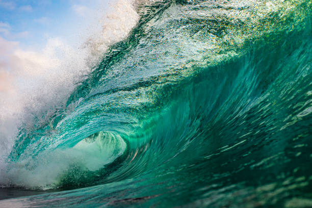 istock Bright blue transparent wave powerfully breaking into ocean 1324403632