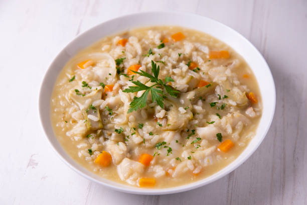 istock Soupy rice with cod, carrot and artichokes. Traditional Spanish tapa. 1324406711
