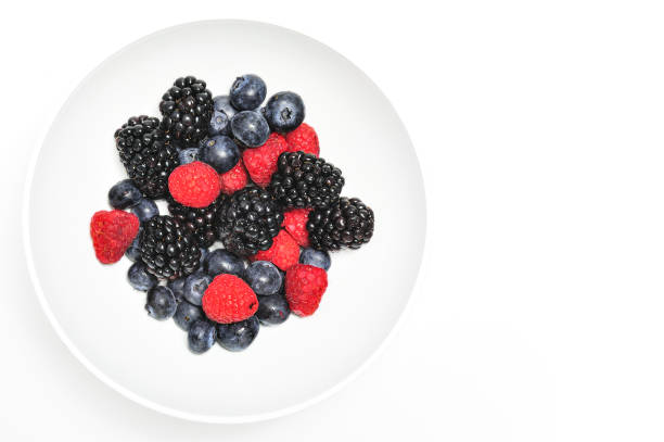 Bowl of healthy fresh fruit on white background, top view