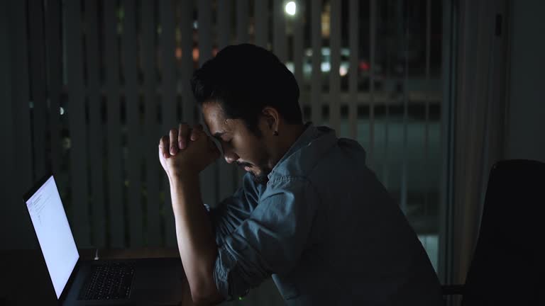 Tired Man With Computer Working Late at Night Office