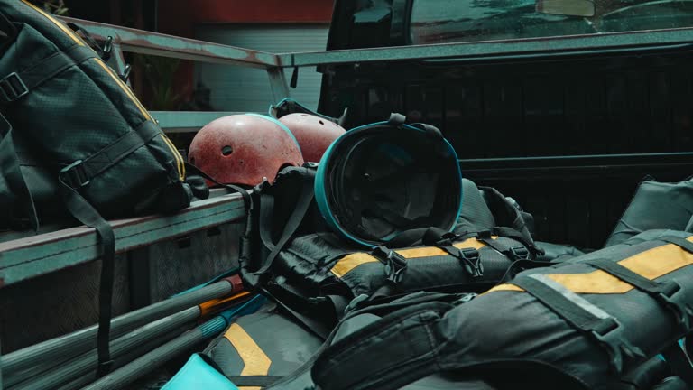 protective jackets with yellow lines and protective helmets to practice rafting lying in the trunk