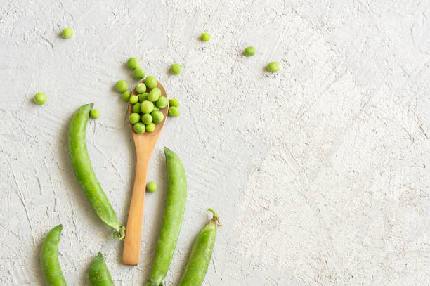 fresh green peas with pod on white rustic background, healthy green vegetable or legume ( pisum sativum ) - green bean bean pod nobody imagens e fotografias de stock