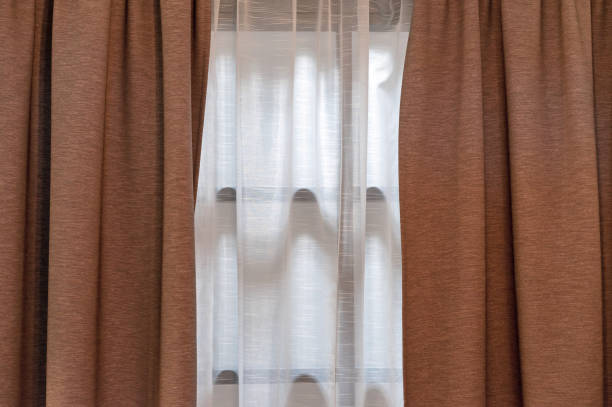 Double-layer curtains in brown blackout fabric and white tulle. Double-layer curtains in brown blackout fabric and white tulle. blackout photos stock pictures, royalty-free photos & images