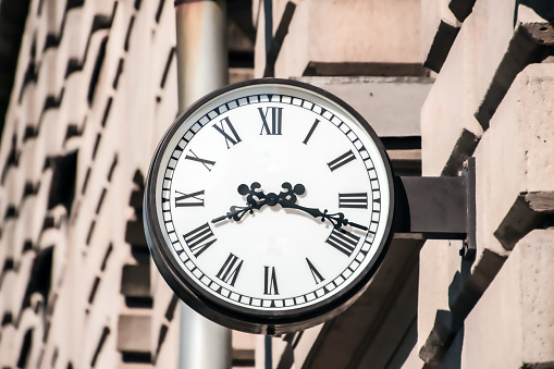 street clock on the wall showing eight o'clock and eighteen minutes