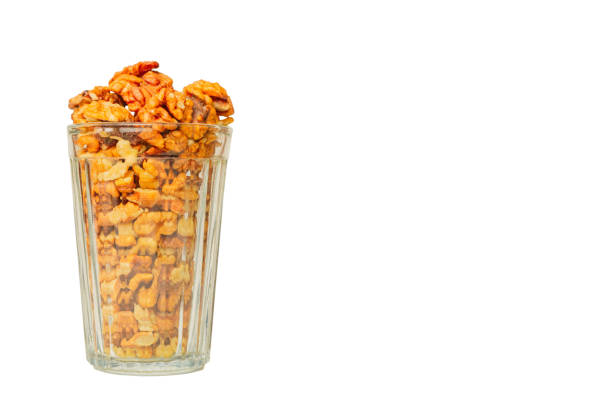 peeled walnut in faceted glass isolated on white background with place for text