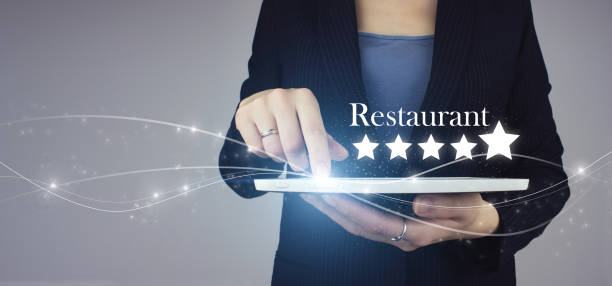 istock Increase rating or ranking, evaluation and classification idea. White tablet in hand with digital hologram Five stars and text Restaurant on grey. Hand pointing five star symbol rating company. 1324422852