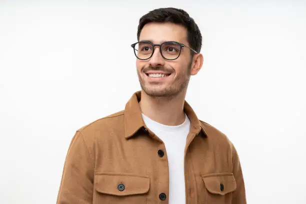 Portrait of handsome man wearing glasses, looking away as if thinking of future, isolated on gray background. Eyewear fashion ads