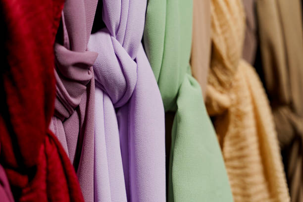 istock Silk scarf muslim. Multi-colored plain scarves on hanger. 1324426337