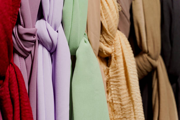istock Silk scarf muslim. Multi-colored plain scarves on hanger. 1324426359