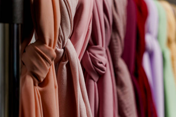 istock Silk scarf muslim. Multi-colored plain scarves on hanger. 1324426388