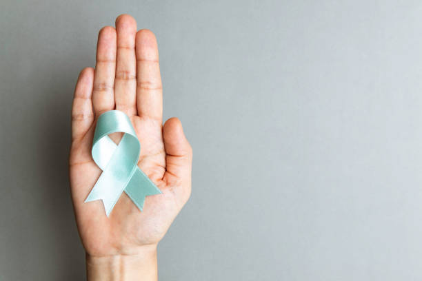 Light Blue Awareness Ribbon Directly above view of a hand holding light blue awareness ribbon over gray background. Some issues for what the blue awareness ribbon stands for are Acid Attacks,Addison’s Disease,Adrenal Insufficiency,Chronic Illness,DiGeorge Syndrome,Dysphagia,Foster Care, Lymphedema,Grave’s Disease,Men’s Health,Prostate Cancer,Thyroid Disease, Movember,Pro-Choice,Pitt-Hopkins Syndrome,Spay and Neuter Pets,Tracheomalacia and Trisomy 5Q. reproductive rights stock pictures, royalty-free photos & images
