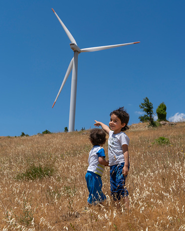Rüzgar enerjisini elektrik enerjisine dönüştüren rüzgar gülü ile tanışan küçük çocuklar. Doğal ışıkta full frame makine ile çekilmiştir.