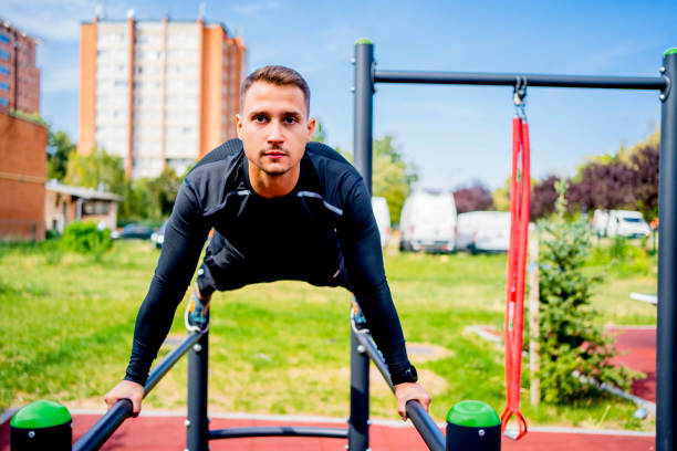 istock Man exercising on parallel bars in the park 1324437420