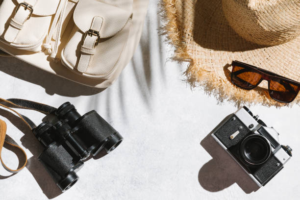 istock Summer holiday concept. Travel flat lay with camera, backpack,  hat on white table background. 1324447349