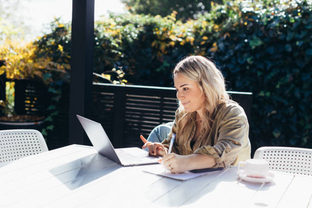 istock Woman sitting outside working on laptop 1324447651