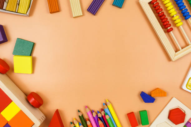 istock Colorful cubes, paints, pencils, blocks, modeling clay on orange background. Interesting math, games for preschool for kids. Education, back to school concept 1324460732