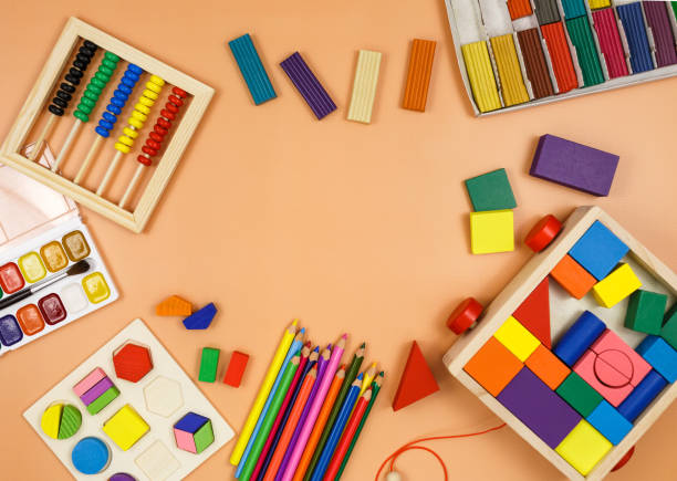 istock Colorful cubes, paints, pencils, blocks, modeling clay on orange background. Interesting math, games for preschool for kids. Education, back to school concept 1324460733