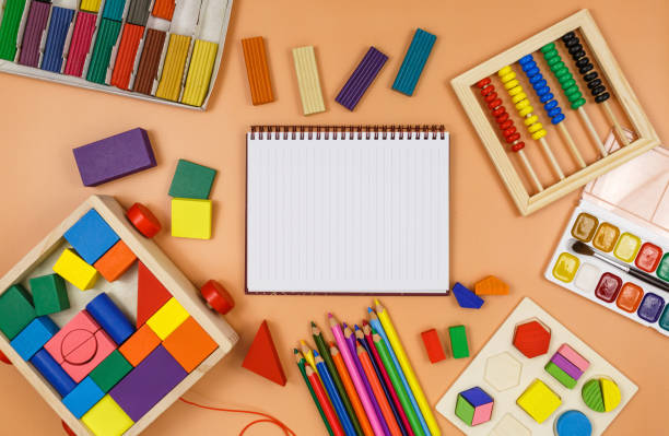 istock Colorful cubes, paints, pencils, blocks, modeling clay on orange background. Interesting math, games for preschool for kids. Education, back to school concept 1324460735