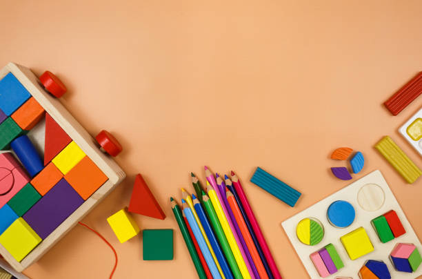 istock Colorful cubes, paints, pencils, blocks, modeling clay on orange background. Interesting math, games for preschool for kids. Education, back to school concept 1324460745