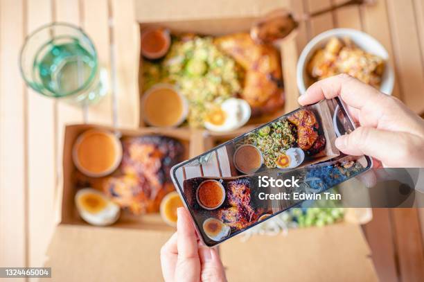 Personal Perspective Human Hand Taking Photo Using Smart Phone On Table Top View Malaysian Food Nasi Kerabu Nasi Ulam And Ayam Percik In Recycled Paper Container With Sauce Stock Photo - Download Image Now