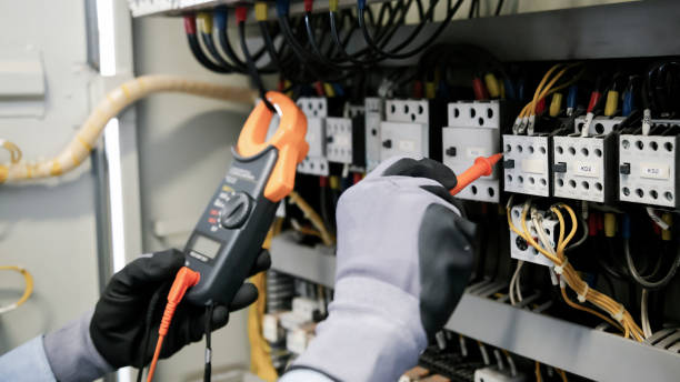 istock Electrical engineers test electrical installations and wiring on protective relays, measuring them with a multimeter. 1324465720