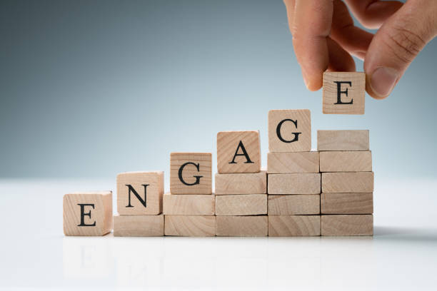 istock Person Arranging Wooden Blocks Showing Engage Text 1324469705