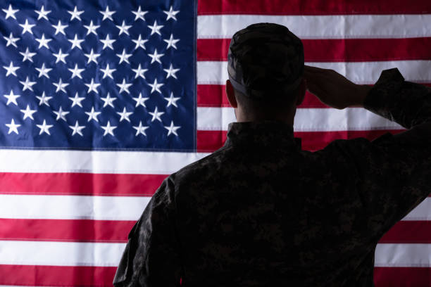 istock Military Man Saluting Us Flag 1324470767