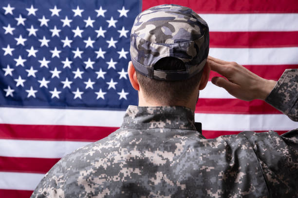 istock Military Man Saluting Us Flag 1324470771