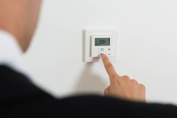 istock Businessperson Setting Temperature On Digital Thermostat 1324471833