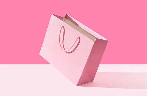 Paper shopping bag on pink background. Shopping sale delivery concept. Packaging template mock up