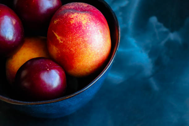 istock Nectarines and plums in a bowl on a table 1324477707
