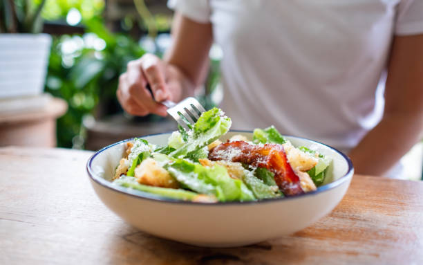 istock a woman eating a Caesar salad 1324482721