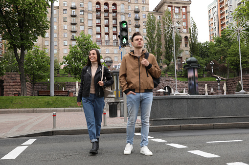 Young people crossing street at traffic lights