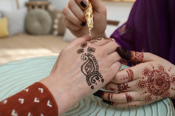 istock Professional mehndi master making henna tattoo indoors, closeup 1324484820