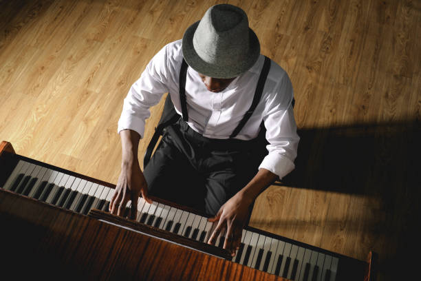 afroamerikanischer mann, der drinnen klavier spielt, oben zu sehen. talentierter musiker - piano keyboard instrument one person piano key stock-fotos und bilder