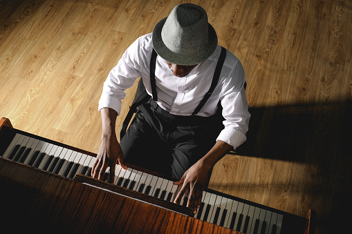 Hombre afroamericano tocando el piano en el interior, por encima de la vista. Músico talentoso photo