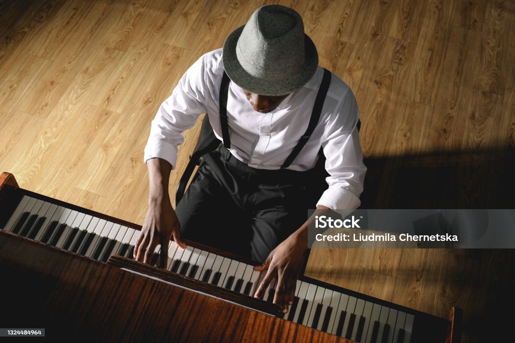 African-American man playing piano indoors, above view. Talented musician Piano Stock Photo